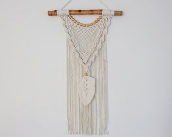 White macrame wall hanging with gold bead accents and birch pole