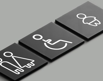May include: Three black square signs with white icons. The first sign has a male and female symbol, the second sign has a wheelchair symbol, and the third sign has a person symbol.