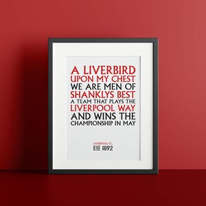 Può includere: Una stampa incorniciata in nero con sfondo bianco e testo rosso. Il testo recita "A Liverbird upon my chest, we are men of Shanklys best, a team that plays the Liverpool way and wins the championship in May." La parte inferiore della stampa recita "Liverpool FC. Est 1892."