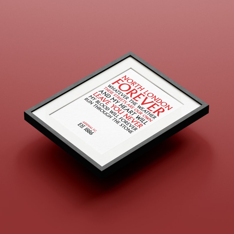 May include: A framed print with the text "NORTH LONDON FOREVER" in red. The text continues with "WHATEVER THE WEATHER THESE STREETS ARE OUR OWN AND MY HEART WILL LEAVE YOU NEVER MY BLOOD WILL FOREVER RUN THROUGH THE STONE". The bottom of the print reads "ARSENAL FC EST 1886".