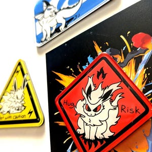 May include: A collection of colorful, cartoon-style magnets featuring various characters. The magnets include a blue and white design with the text "Suspicious Zone", a yellow triangle with the text "Pet with caution", and a red square with the text "Huge Risk".