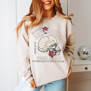 May include: A beige sweatshirt with a skull graphic and the text "He makes dry bones come alive Ezekiel 37:1-10 Dry bones hear the word of the Lord"
