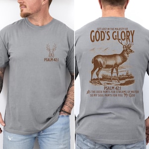 A gray t-shirt with a brown deer silhouette and the text 'PSALM 42:1' on the front. On the back the text 'GET LOST IN THE MAJESTY OF GOD'S GLORY' and a brown deer silhouette. Mens Christian Shirts, Bible Verse Shirt, Hunting Gifts, Husband Gift, Deer Hunter, Father's Day Gift, Jesus Shirt, Adult Baptism Gifts, Men's Shirt, Religious Shirt, Christian Gift, Religious Gift For Men, Hunting T-shirt, Deer Tshirt, Comfort Colors Tshirt
