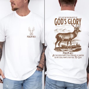 White t-shirt with a brown deer silhouette and  'PSALM 42:1' on the front. The back of the shirt has a deer silhouette with the text 'GET LOST IN THE MAJESTY OF GOD'S GLORY', Mens Christian Shirts, Bible Verse Shirt, Hunting Gifts, Husband Gift, Deer Hunter, Father's Day Gift, Jesus Shirt, Adult Baptism Gifts, Men's Shirt, Religious Shirt, Christian Gift, Religious Gift For Men, Hunting T-shirt, Deer Tshirt, Comfort Colors Tshirt