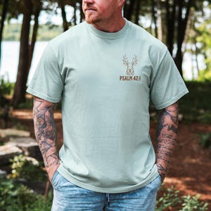 May include: A light sage green t-shirt with a brown deer silhouette and the text 'PSALM 42:1'. Mens Christian Shirts, Bible Verse Shirt, Hunting Gifts, Husband Gift, Deer Hunter, Father's Day Gift, Jesus Shirt, Adult Baptism Gifts, Men's Shirt, Religious Shirt, Christian Gift, Religious Gift For Men, Hunting T-shirt, Deer Tshirt, Comfort Colors Tshirt