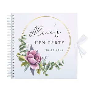 May include: A white spiral bound guest book with a gold circle frame and the text "Alice's Hen Party 08.12.2022". The frame is decorated with watercolor illustrations of pink flowers and green leaves.