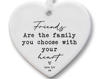 Pode incluir: Adorno de coração branco de cerâmica com o texto "Friends Are the family you choose with your heart" e a assinatura "Love Liv XX".