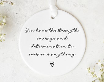 May include: White ceramic ornament with the text "You have the strength, courage and determination to overcome anything" and a small heart at the bottom.