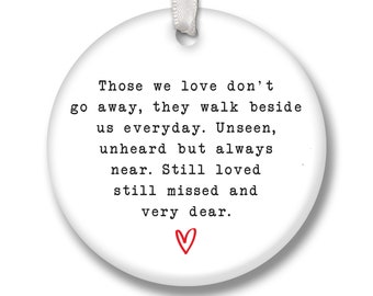 May include: White round ornament with a black and white text quote: "Those we love don't go away, they walk beside us everyday. Unseen, unheard but always near. Still loved still missed and very dear."  A red heart is at the bottom of the quote.