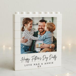 May include: White Lego-style photo block with a photo of a father with two children. The text "Happy Father's Day Daddy Love Max & Annie XX" is printed on the bottom of the block.