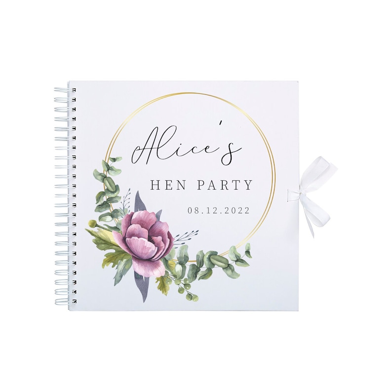 May include: A white spiral bound guest book with a gold circle frame and the text "Alice's Hen Party 08.12.2022". The frame is decorated with watercolor illustrations of pink flowers and green leaves.