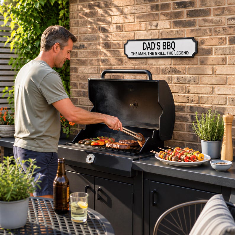 A man grilling food on a barbecue grill, with a sign that reads "DAD'S BBQ" above it.