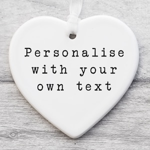May include: White ceramic heart-shaped ornament with the text "Personalise with your own text" printed in black.