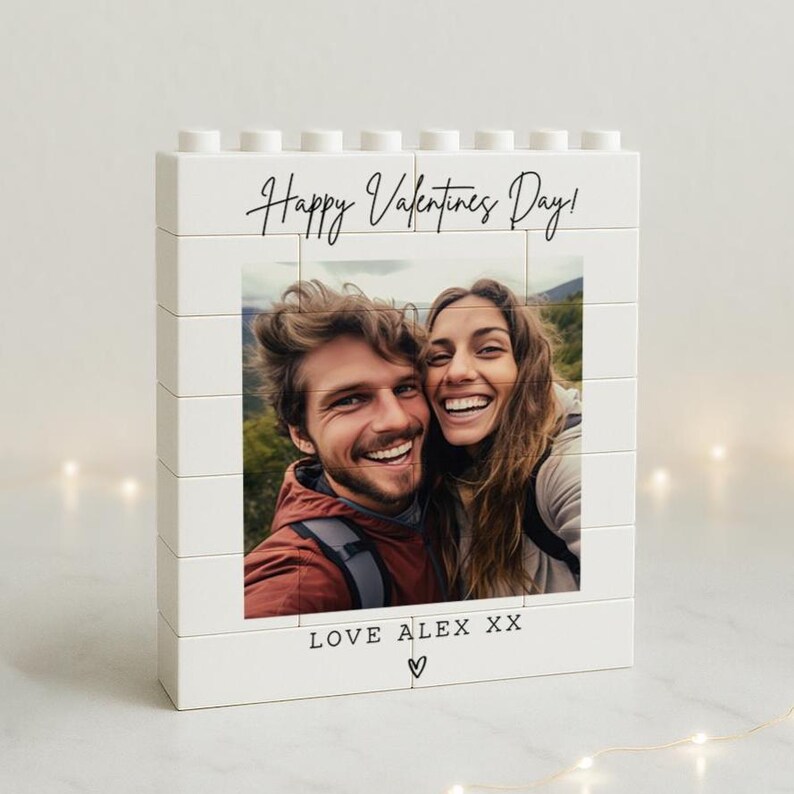 May include: A white block photo frame with a picture of a smiling couple. The frame has the text "Happy Valentines Day!" and "LOVE ALEX XX" with a heart symbol.