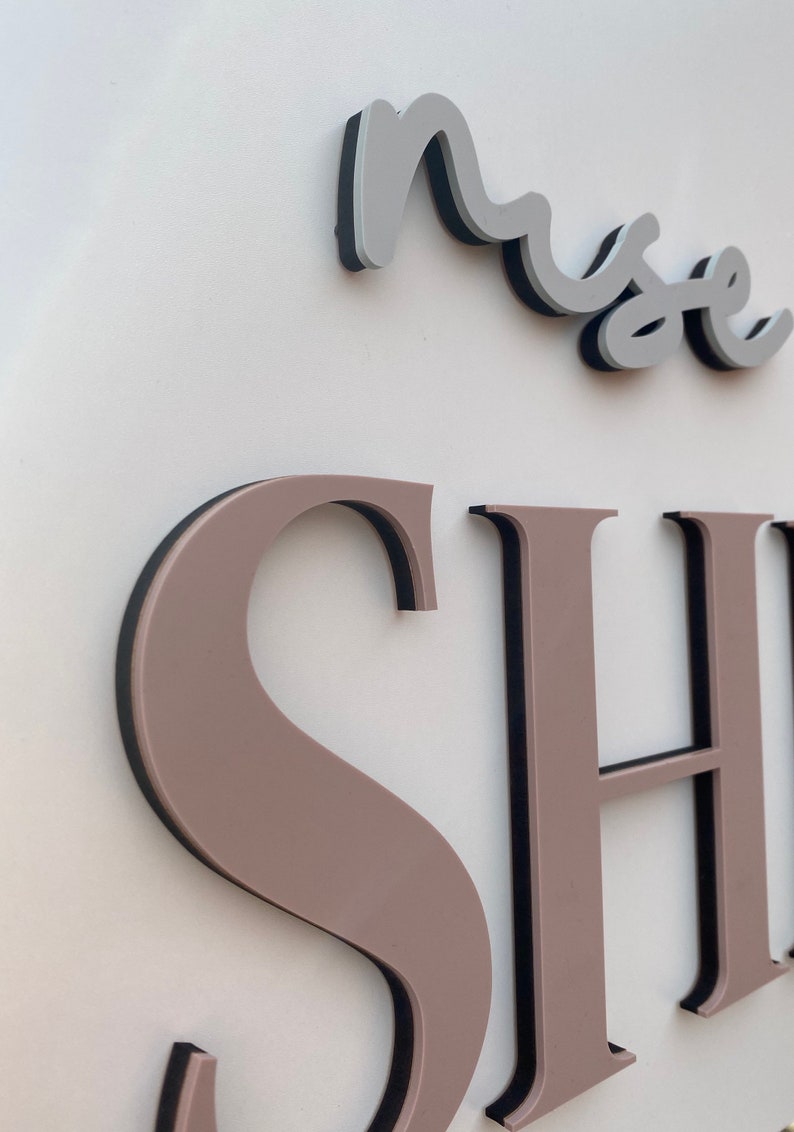 May include: A close-up of a sign with the word "muse" in a cursive font above the word "SHOP" in large, block letters. The letters are raised and have a black outline.