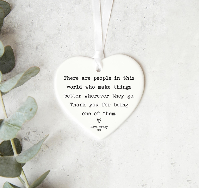 a heart-shaped ornament with a quote about people making things better where they go and being one of them.