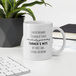 May include: White ceramic coffee mug with black text that reads "I never dreamed I'd grow up to be a ridiculously good-looking farmer's wife but here I am, living the dream."