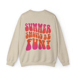 May include: A beige sweatshirt with a pink and orange graphic print that says "Summer should be fun!" in a retro font.