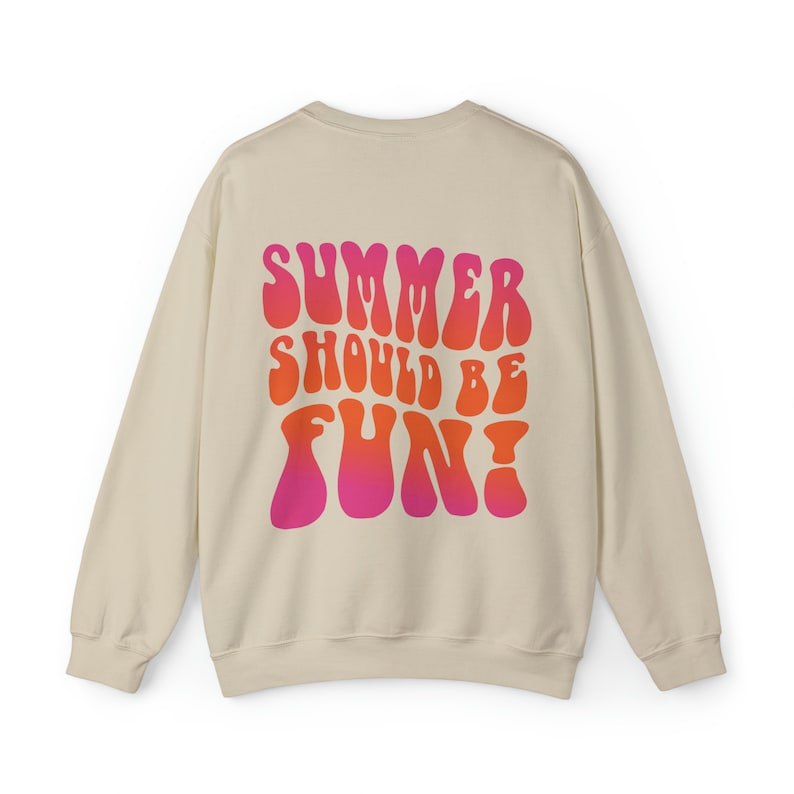 May include: A beige sweatshirt with a pink and orange graphic print that says "Summer should be fun!" in a retro font.