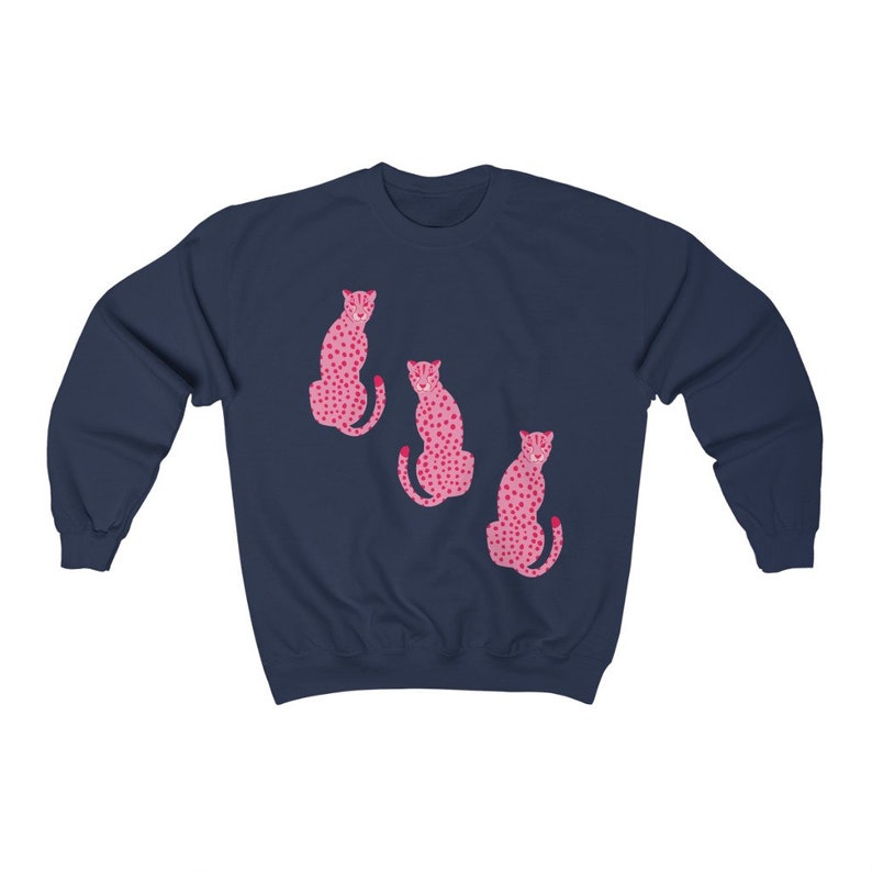 May include: A navy blue sweatshirt with a pink leopard print design. The design features three leopards sitting in a row.
