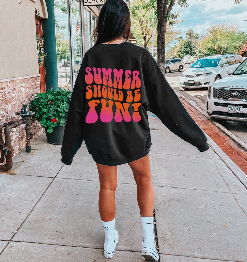 May include: A black sweatshirt with a pink and orange graphic print that says "Summer should be fun!" The graphic is in a retro, psychedelic font.