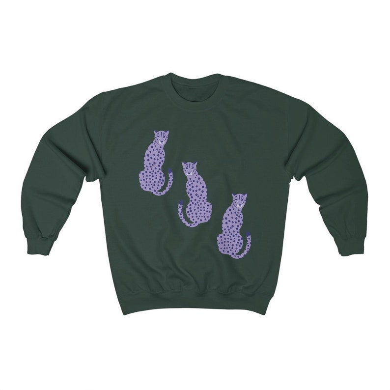 May include: A dark green sweatshirt with a graphic print of three purple cheetahs. The cheetahs are sitting down and facing different directions.