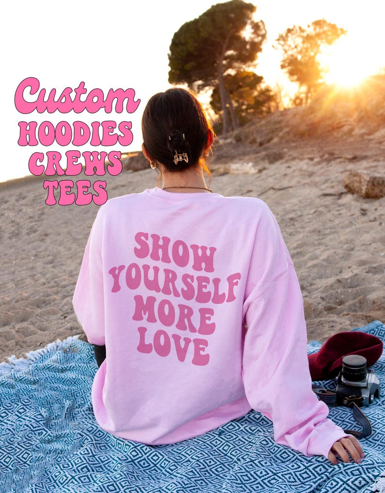 May include: A pink long-sleeved sweatshirt with the text "Show Yourself More Love" in pink letters on the back.