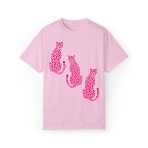 K&ouml;nnte beinhalten: Pinkes T-Shirt mit einem Motiv von drei pinkfarbenen Geparden mit schwarzen Flecken.
