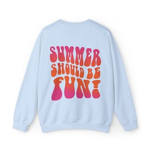 May include: Light blue sweatshirt with a graphic print of the text "SUMMER SHOULD BE FUN!" in a retro, psychedelic font with a gradient of pink and orange.