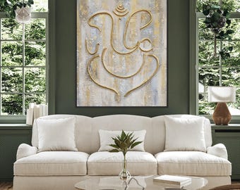May include: A white sofa with two white pillows and a green plant on a glass coffee table in front of a painting of a gold Ganesha on a textured background.