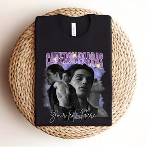 May include: Black t-shirt featuring a purple graphic of three men. The graphic includes the text "Cameron Porras" and "Your Text Here".