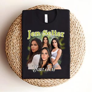 May include: Black t-shirt featuring a graphic of four women. The text "Jen Selter" is printed in green above the graphic. The text "Your Text" is printed in white below the graphic.