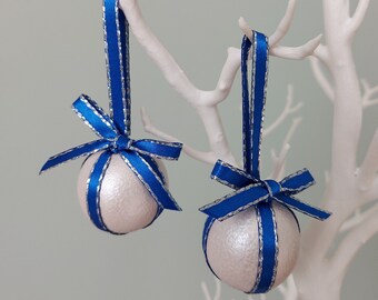 Silberfarbener Christbaumschmuck mit blauem/silbernem Band