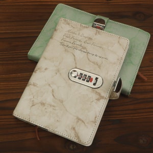 May include: A white marble-patterned journal with a silver combination lock and a green cover peeking out from underneath. The journal has the text "Moten & Depth: First Friends Best Friends, Forever Friends. Thanks for always being by my side." written on the front.