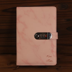 May include: Pink marble-patterned notebook with a combination lock and the text "Kari Mom" in cursive.