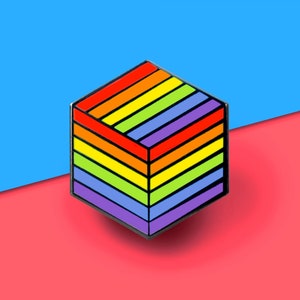 May include: A rainbow-colored enamel pin shaped like a cube. The pin has a black outline and is made of metal.