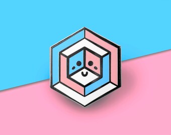 May include: A pink and blue enamel pin with a geometric design. The pin features a smiling face with two eyes and a mouth. The pin is shaped like a hexagon.