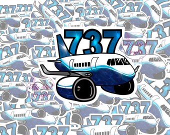 以下が含まれることがあります： 前面に737の数字が書かれた青と白の飛行機のステッカー。飛行機は同じデザインの小さなステッカーで囲まれています。