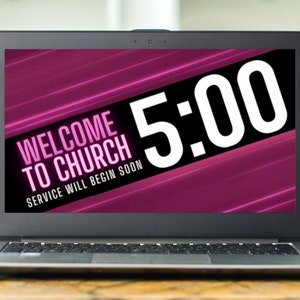 May include: A laptop screen displaying a pink and black background with white text that reads "Welcome to Church" and "Service will begin soon". The time 5:00 is displayed in large white font.