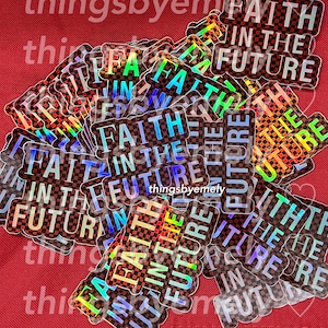 Può includere: Un mucchio di adesivi iridescenti con un motivo a scacchi e il testo "Faith in the Future".