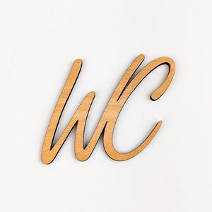 May include: Wooden sign with the letters "WC" in a cursive font.