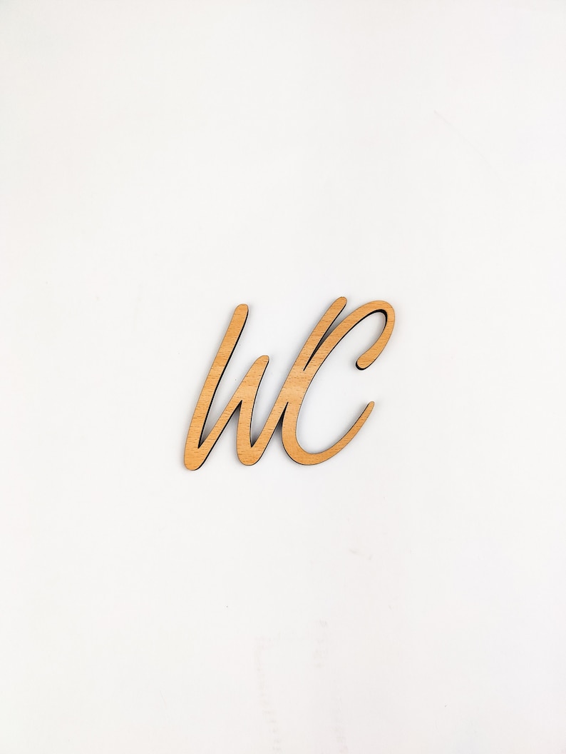May include: Wooden sign with the letters "WC" in a cursive font.