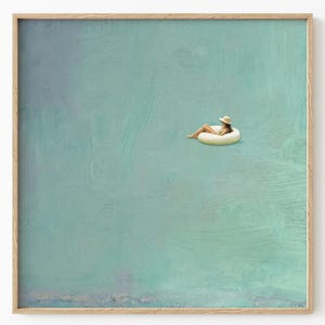 Puede incluir: Una impresión artística enmarcada que representa a una persona relajándose en una boya inflable blanca en agua turquesa. La persona lleva un sombrero de paja. La obra de arte tiene un aspecto texturizado y pintado, con un marco de madera.
