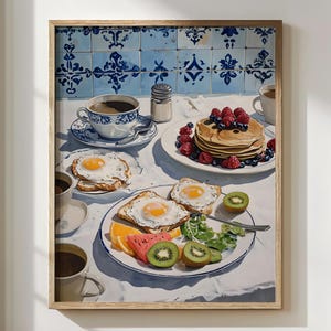 Fine art brunch wall print featuring a Mediterranean breakfast table with fried eggs on toast, golden pancakes topped with berries, fresh fruit slices, and steaming coffee in blue-and-white china cups. Set against a tiled kitchen wall, this cozy artwork brings warmth and vintage farmhouse charm. Perfect holiday kitchen art, Christmas foodie gift, or stylish decor for cafés, brunch lovers, and festive Airbnb interiors.