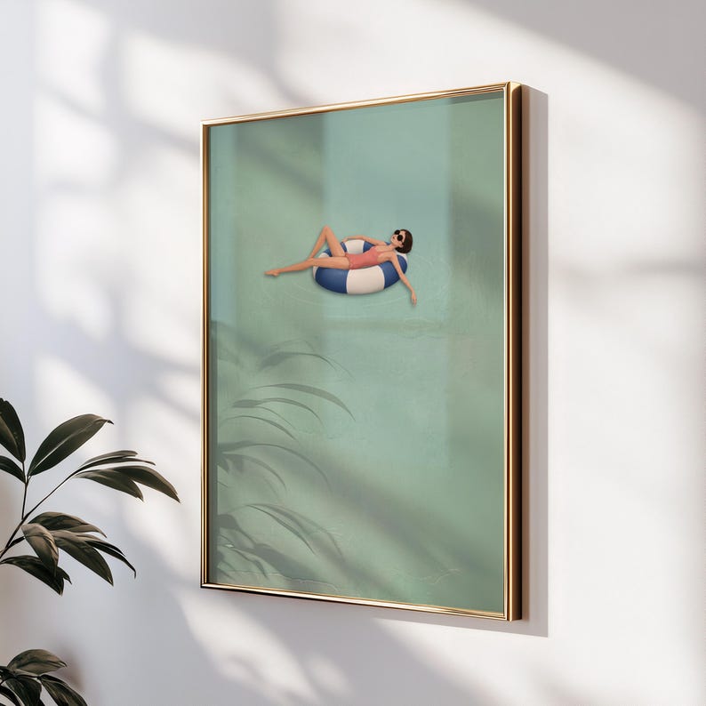 Pu&ograve; includere: Una stampa artistica incorniciata che raffigura una persona con costume da bagno rosa e occhiali da sole, che galleggia su un salvagente a righe blu e bianche in una piscina verde chiaro. L'opera &egrave; racchiusa in una sottile cornice color oro.