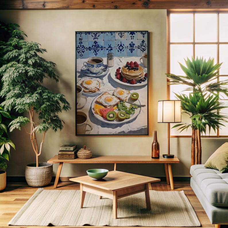 Puede incluir: Una pintura enmarcada representa una escena de desayuno con panqueques, huevos, fruta y caf&eacute;. La obra de arte se encuentra sobre un fondo de azulejos azules y blancos. La habitaci&oacute;n cuenta con un banco de madera, una mesa de centro y un cuenco verde. Las plantas y una l&aacute;mpara completan la decoraci&oacute;n.