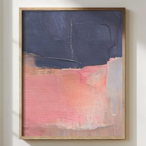Könnte beinhalten: Abstrakter Kunstdruck in einem Holzrahmen. Das Kunstwerk zeigt strukturierte Pinselstriche in den Farbtönen Marineblau, Rosa und Pfirsich. Das Gemälde ist ein vertikales Rechteck, geeignet für die Wanddekoration. Der Rahmen ist hellbraun.