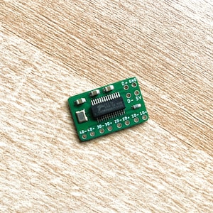 May include: A green circuit board with a small integrated circuit chip and labelled pins for power and ground. The board has labels for 4.0, 3.0, 2.0, 1.0, 10, 20, 30, and GND.