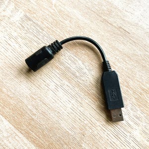 May include: A black USB cable with a male USB connector on one end and a smaller, round connector on the other end.