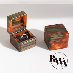 MUSE – Proposta di matrimonio con scatola porta-anello in resina arancione e legno nero. Porta-anello di fidanzamento in resina epossidica di lusso. Esclusivo espositore per anello in legno